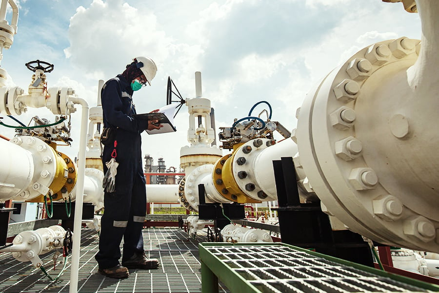 An engineer checking the valves on an oil pipeline