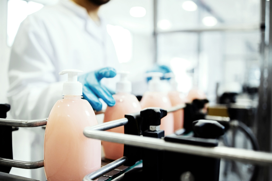 Technician at a co-packaging facility filling bottles on an assembly line