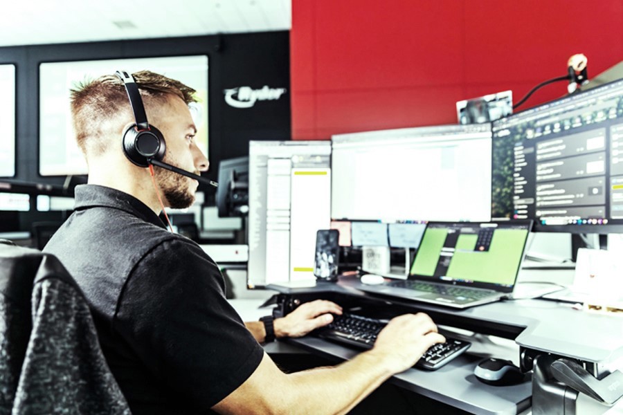 Employee at his desk in front of multiple desktop screens